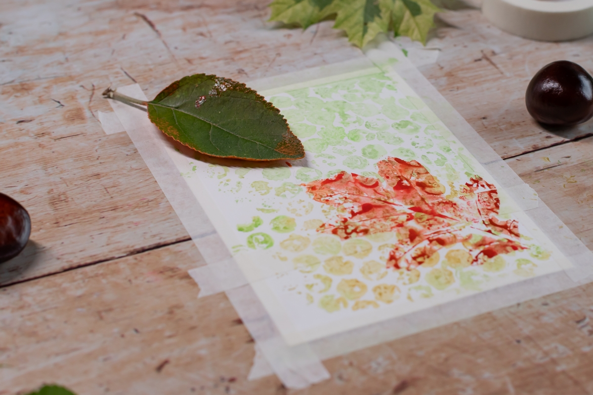 Farbige Adr&uuml;cke von einem Pflanzenblatt auf einem Blatt Papier.