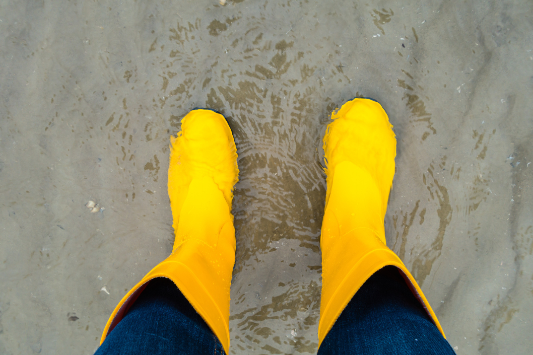 Gelbe Gummistiefel im Watt