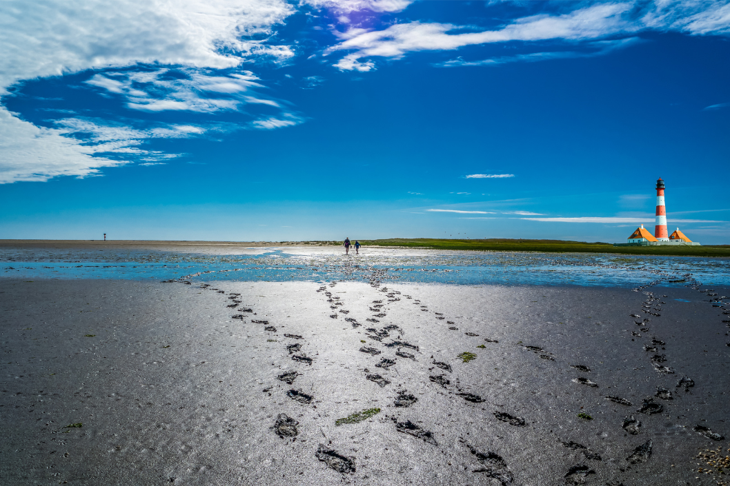 Zwei Personen spazieren durch das Wattenmeer